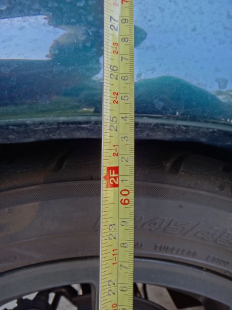 1995 Ford Taurus - A tape measure is shown next to the wheel well and tire of a vehicle.