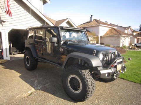 2008 Jeep Wrangler - Modified black Jeep Wrangler parked in front of a residential garage.