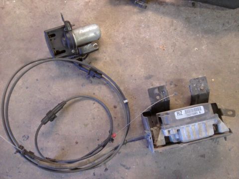 2005 Honda CR125R - Two vehicle components, a motor with cables and a control module, are laid out on a concrete surface.