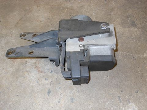 2005 Honda CR125R - ABS control module with a metal mounting bracket is shown against a concrete background.