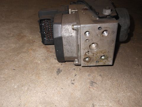 2005 Honda CR125R - Close-up view of an automotive ABS module, showing its electrical connector and hydraulic fittings.