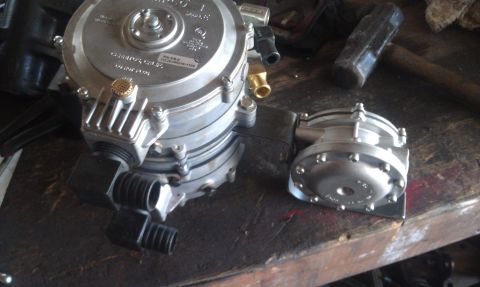 1978 Ford Bronco - Close-up of a propane regulator and a smaller filter component on a wooden surface.