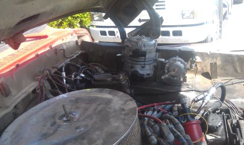 1978 Ford Bronco - The engine bay shows a propane conversion system, with a second vehicle visible behind it.