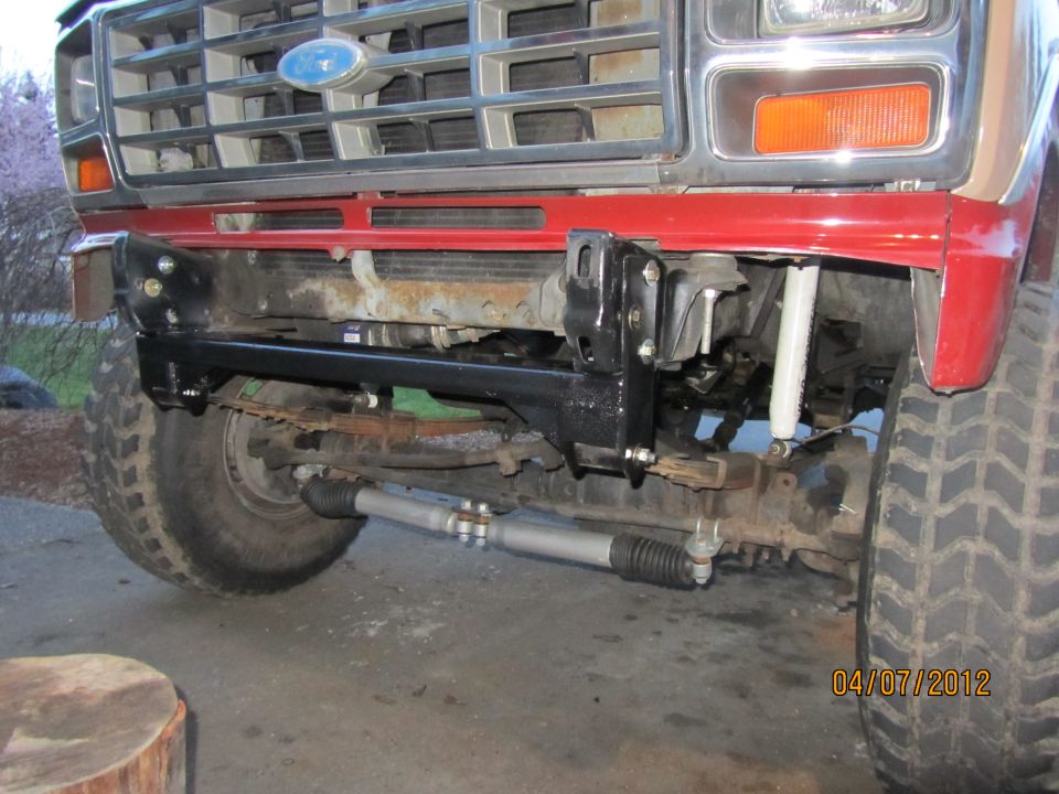 1980 Ford Bronco front grille, bumper, and suspension components. Red fender visible