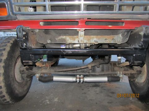 1984 Ford Bronco - Close-up view of the front underside of a vehicle, highlighting the steering and suspension system.