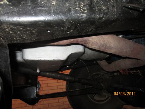 1979 Ford Bronco - The underside of a vehicle is visible, with focus on the transmission pan and exhaust system.