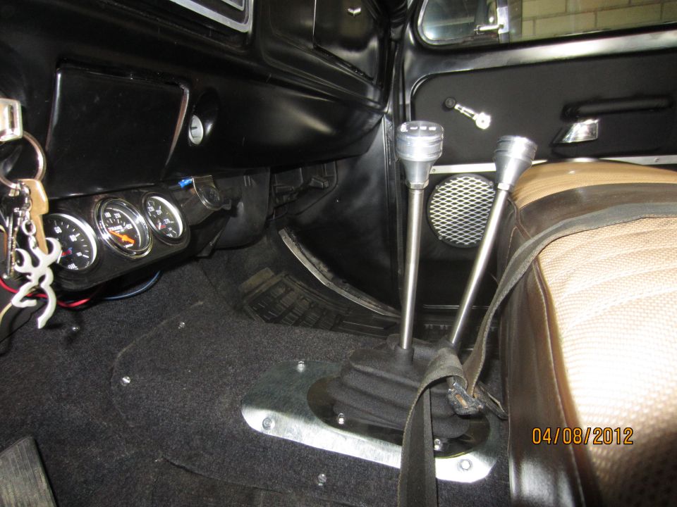 Interior view of a 1979 Ford Bronco showing the dashboard, two gear shifters, and auxiliary gauges
