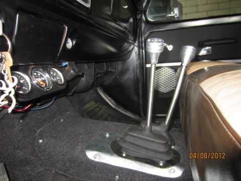 1979 Ford Bronco - The interior of a vehicle features dual shifters and auxiliary gauges mounted below the dashboard.