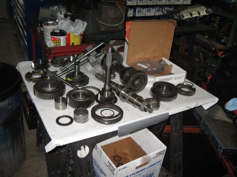 1994 Ford Bronco - Various transmission components are spread across a white cloth on a workbench.