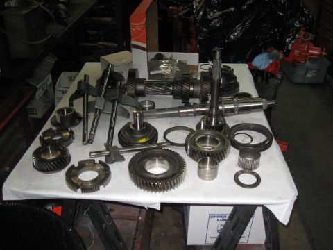 1994 Ford Bronco - Various transmission components are laid out on a table, including gears, shafts, and synchronizer rings.