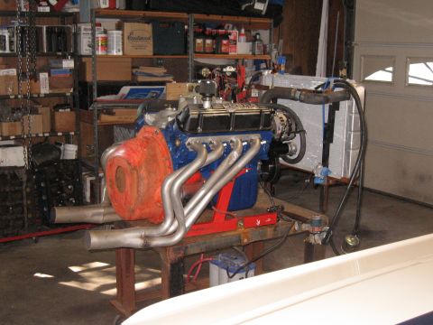 1994 Ford Bronco - Engine assembly with headers and radiator displayed in a garage setting.