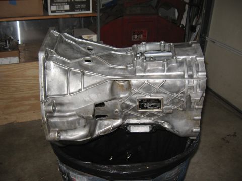 1994 Ford Bronco - Transmission casing with a data plate, likely from a vehicle, shown in a workshop setting.