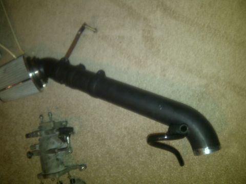 2000 Ford Crown Victoria - Aftermarket cold air intake system components laid out on a carpeted surface.