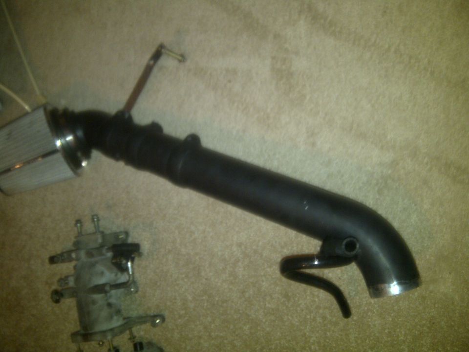 aftermarket cold air intake system with chrome air filter and black tubing