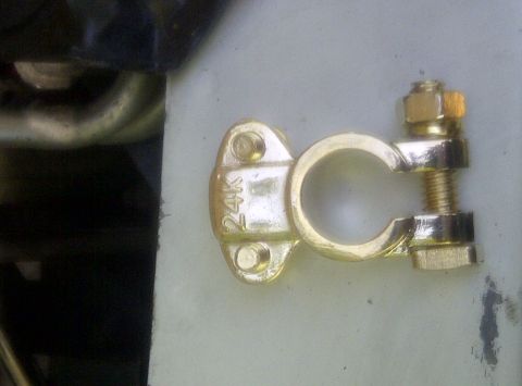 2000 Ford Crown Victoria - A close-up view of a gold-plated battery terminal clamp, marked with "24K".