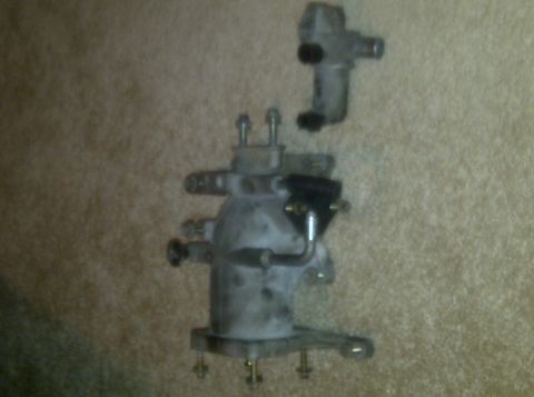 2000 Ford Crown Victoria - A brake master cylinder assembly, likely removed for repair or replacement, is shown against a textured background.