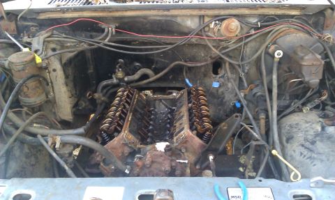 1986 Ford Bronco - Engine bay with V8 engine exposed, wires and hoses visible, indicating a work in progress.