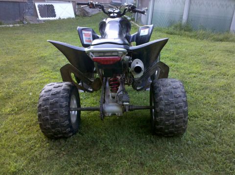 2005 Honda TRX 450 R - This ATV is parked on a grassy area with a building in the background. The rear of the vehicle is visible.