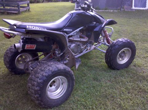 2005 Honda TRX 450 R - This black Honda TRX 450 R ATV features an aftermarket exhaust and is shown in a grassy outdoor setting.