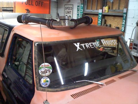 1978 Ford Bronco - A pink SUV, possibly a classic model, is equipped with a roof rack and a "Truck" sticker on the windshield.