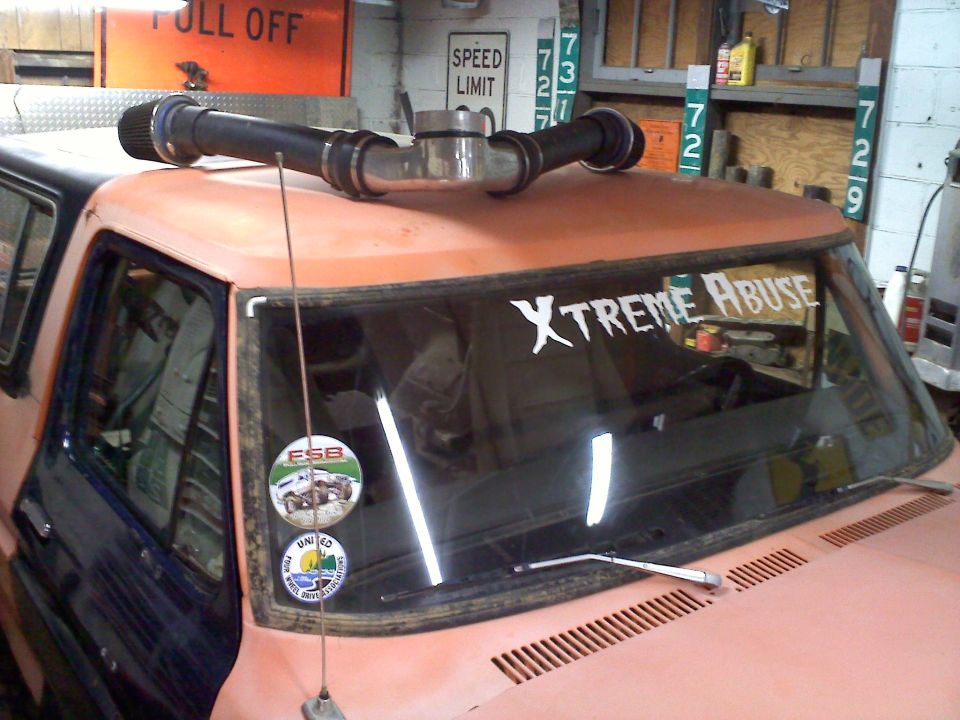 Pink SUV with roof rack and "Truck" sticker on windshield