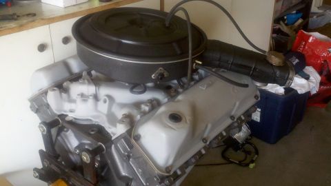 1978 Ford Bronco - Engine part shown in a workshop setting with various items in the background.
