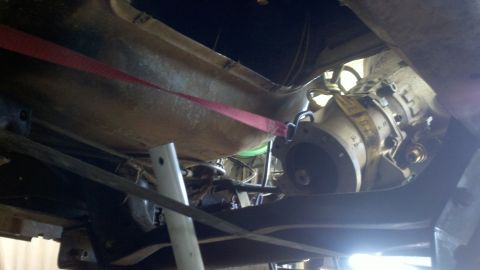 1978 Ford Bronco - The transmission is suspended from the vehicle's undercarriage for removal or installation.