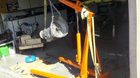 1978 Ford Bronco - Engine hoist lifting a transmission and engine assembly in a garage setting.
