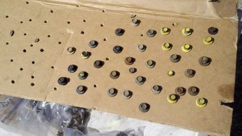 1978 Ford Bronco - Various bolts and nuts are laid out on a piece of cardboard, likely for a motor rebuild project.