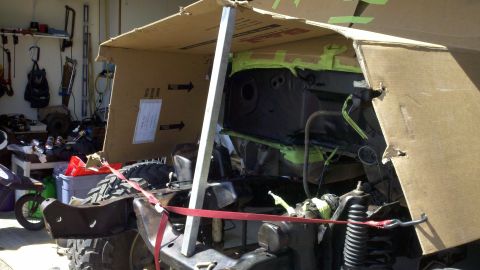 1978 Ford Bronco - The vehicle's chassis and engine bay are partially covered with cardboard and metal supports during a project.