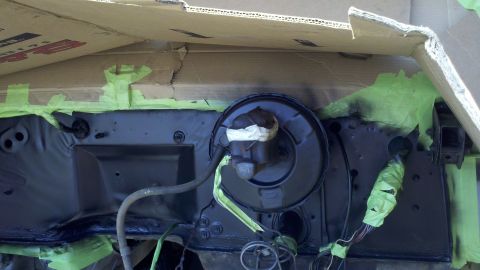 1978 Ford Bronco - A close-up view of a brake booster and firewall assembly, partially covered with green masking tape during a rebuild.