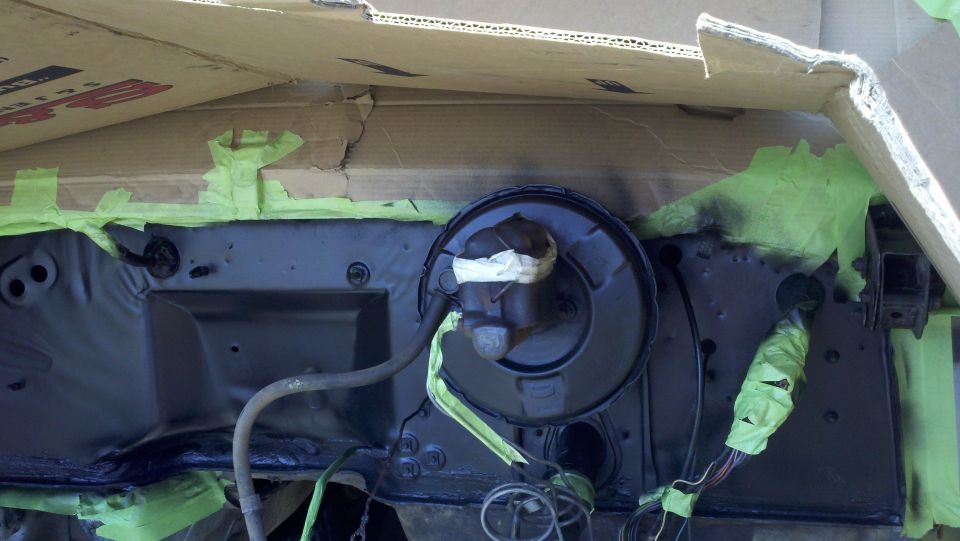 Brake booster and firewall assembly covered in green tape