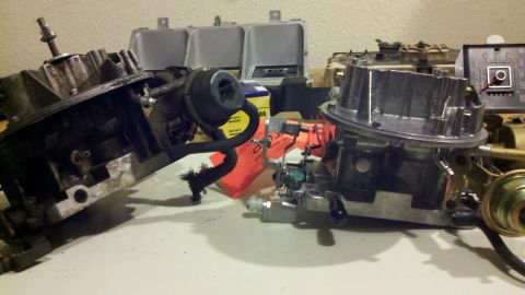 1978 Ford Bronco - Two carburetors are laid out on a surface, possibly for repair or replacement.