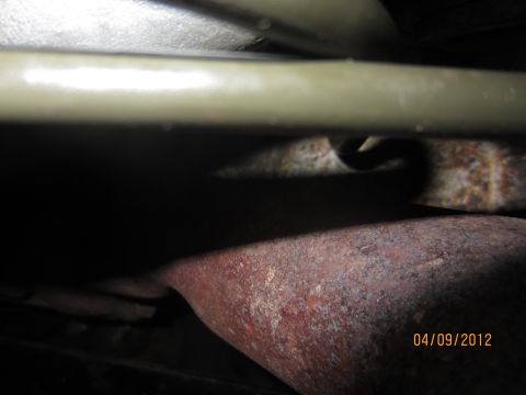 1979 Ford Bronco - Underside view of a rusty exhaust pipe and frame, with a date stamp of 04/09/2012.