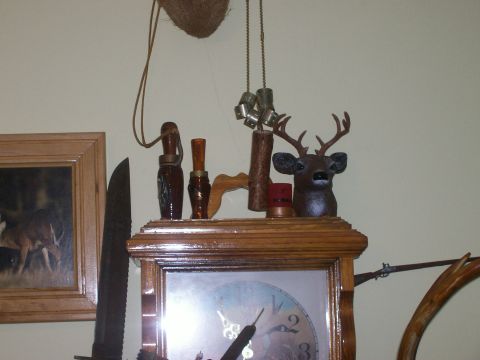 1993 Ford Bronco - A decorative clock features a mounted deer head, duck calls, and a shotgun shell, alongside a framed picture of a deer.