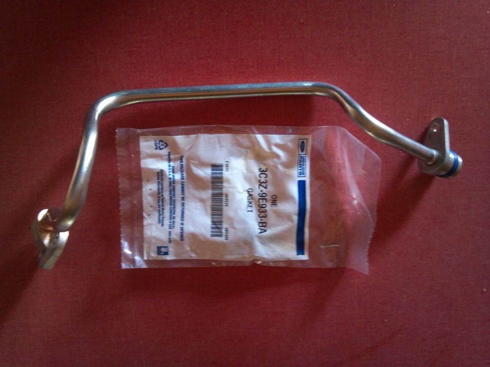 Metal tube and a plastic bag with a Ford part number 3C3Z-9E933-BA