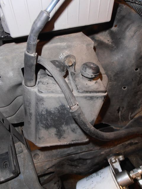 1990 Ford Bronco - Close-up of an engine bay component with hoses, likely part of the emissions system.