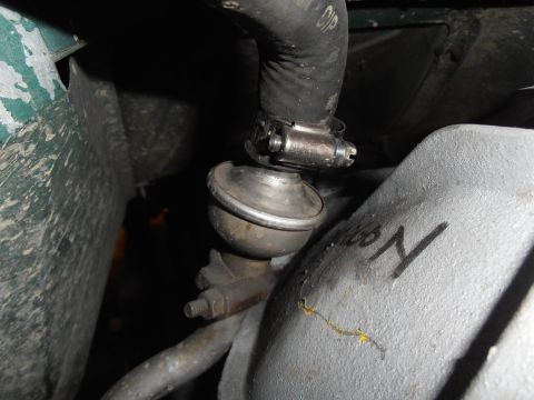 1990 Ford Bronco - A close-up view of a vehicle's engine bay, focusing on a vacuum hose and valve assembly.
