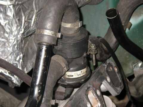 1990 Ford Bronco - Close-up of a Ford emissions component, part number F22B-289-AA, with hoses and clamps.