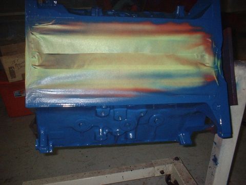 1957 Ford Custom Sedan - Engine block is being painted blue with masking tape applied to sections.
