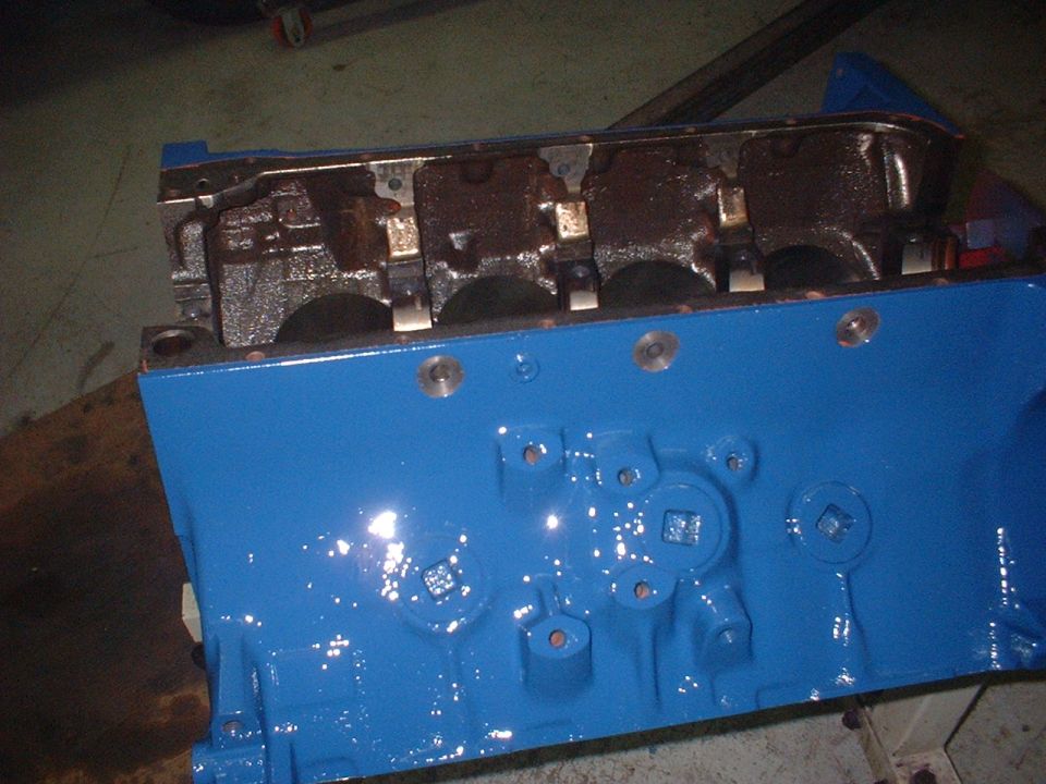 Blue painted engine block with visible internal components and bolt holes
