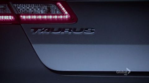 1993 Ford Taurus - Car's rear badging clearly shows 'TAURUS' next to an illuminated LED taillight.