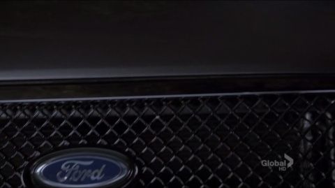 1993 Ford Taurus - Close-up of a Ford emblem on a black grille.