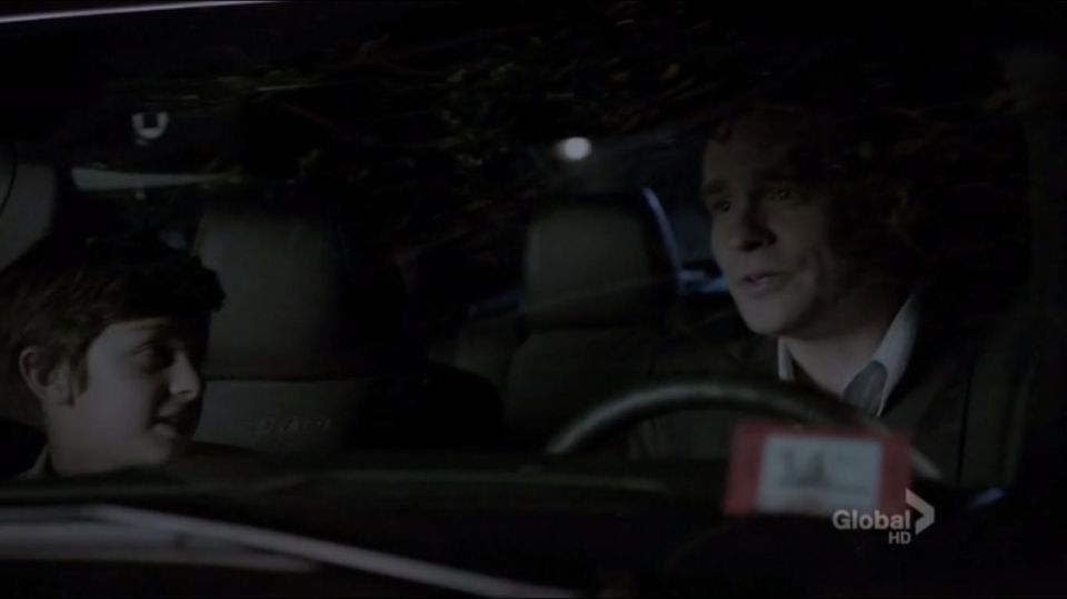 guy driving car at night, kid in passenger seat