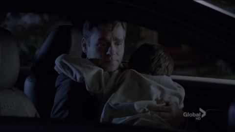 1993 Ford Taurus - A man clutches a child in the dark interior of a car, with 'SHO' visible on a headrest.