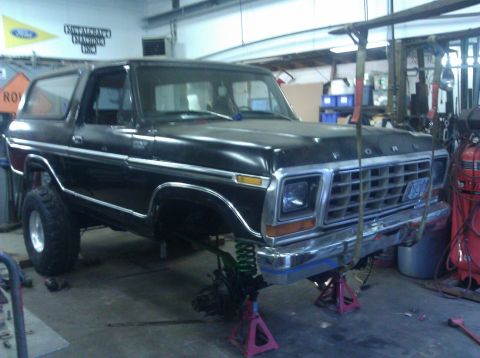 1979 Ford Bronco - This black Ford Bronco is undergoing front-end work in a garage.