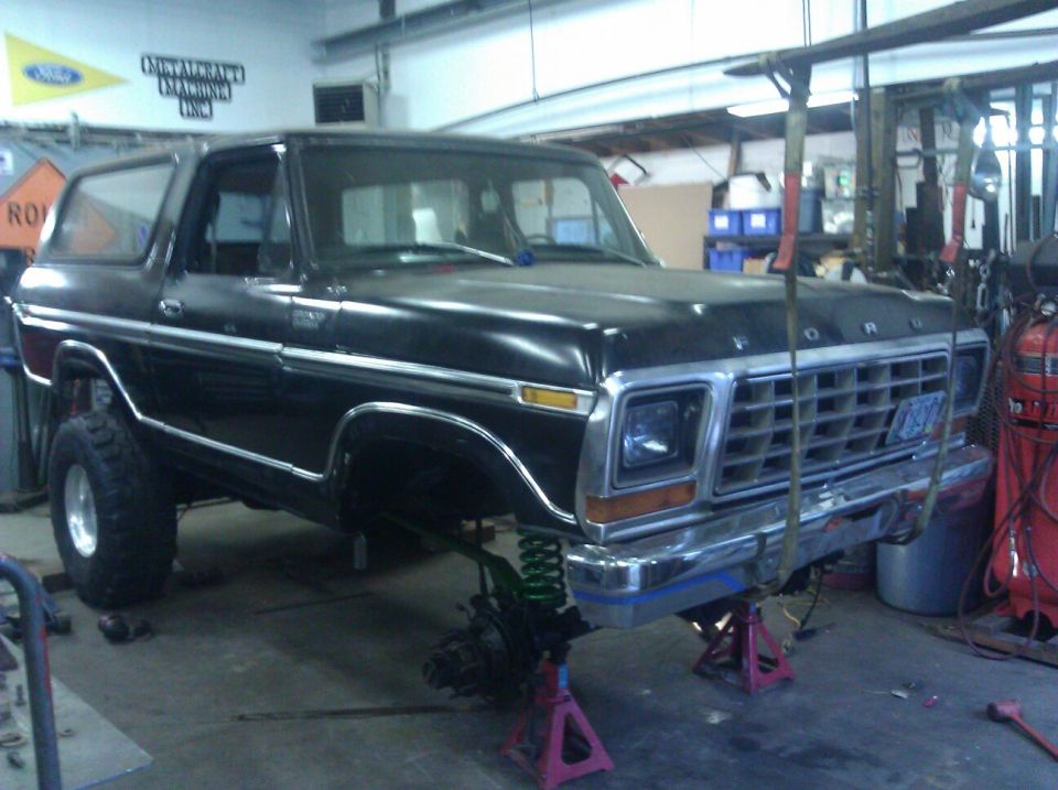 Black 1978 Ford Bronco on jack stands with front end disassembled