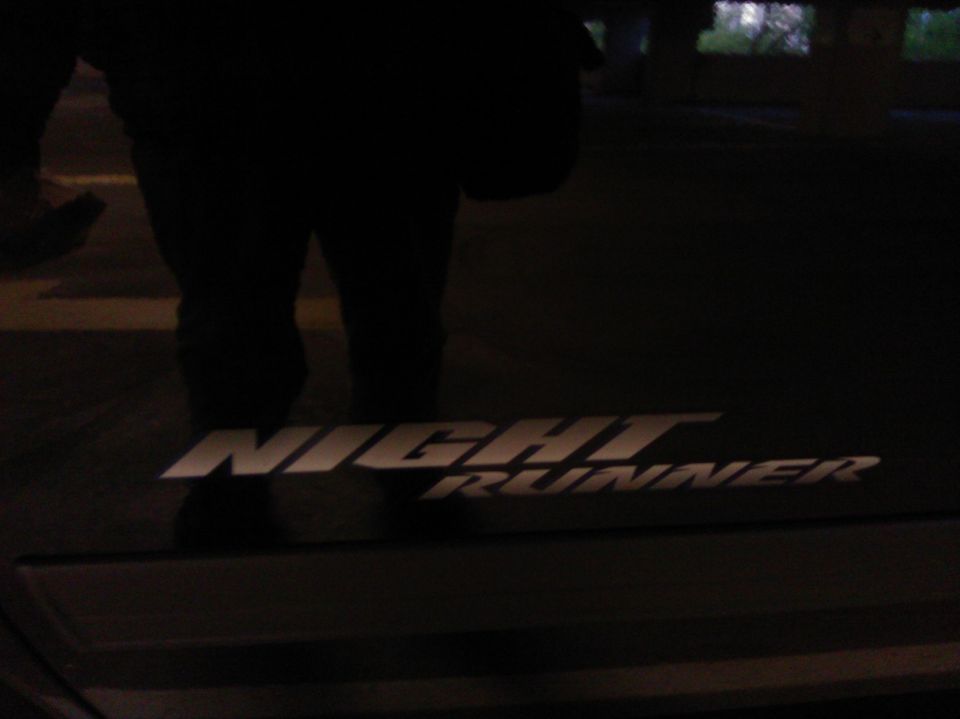 Silver 'Night Runner' text emblem on a dark background