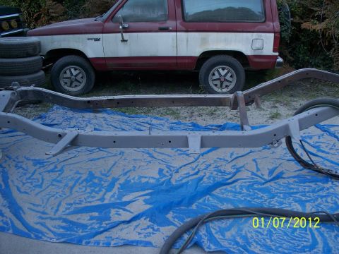 1990 Ford Bronco - 1990 Ford Bronco parked behind its chassis, which is laid out on a blue tarp.