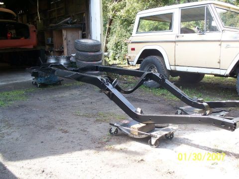 1990 Ford Bronco - A black frame sits in front of a tan Ford Bronco in a garage setting.